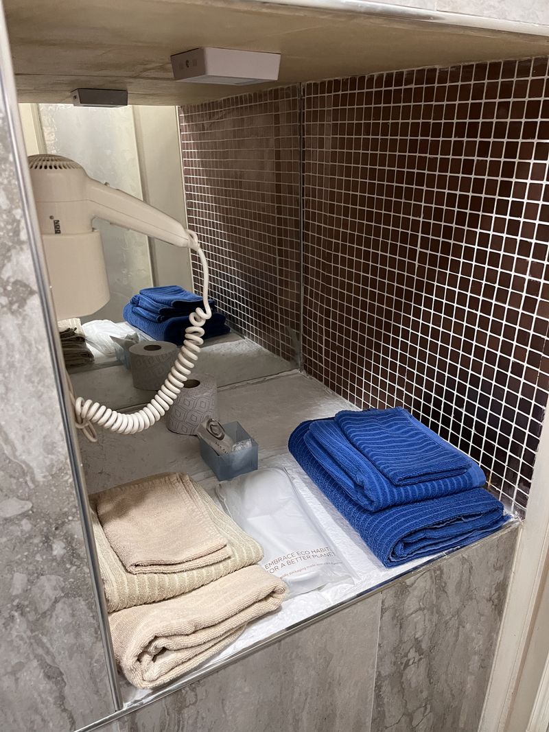 Fresh towels and a hairdryer waiting in a niche in the bathroom.