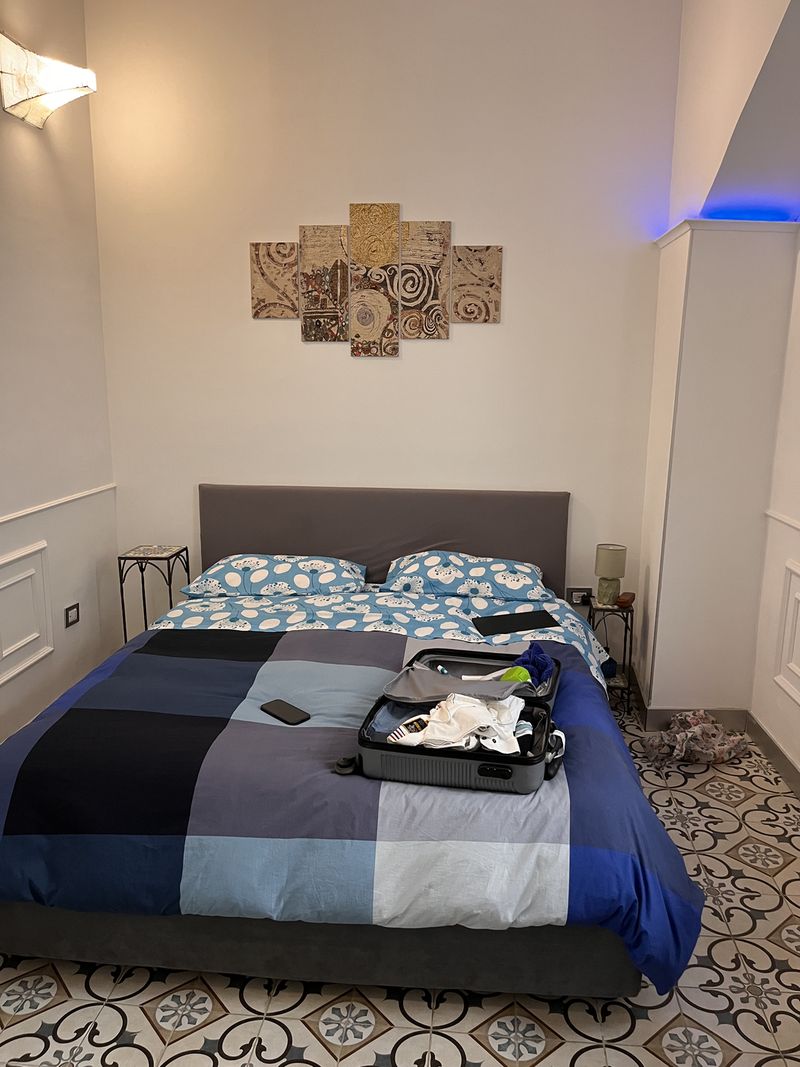 The bedroom, with the suitcase already half unpacked on the bed.