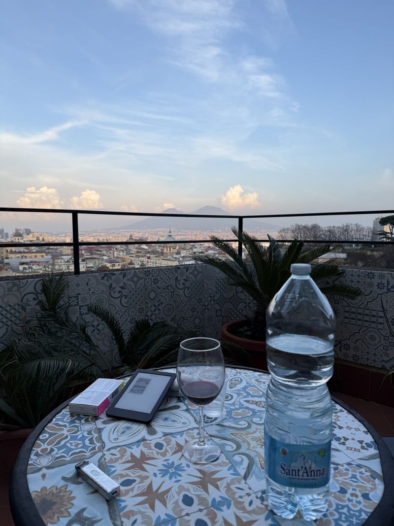 Late afternoon: a glass of wine at the mosaic table, with Vesuvius in the distance.
