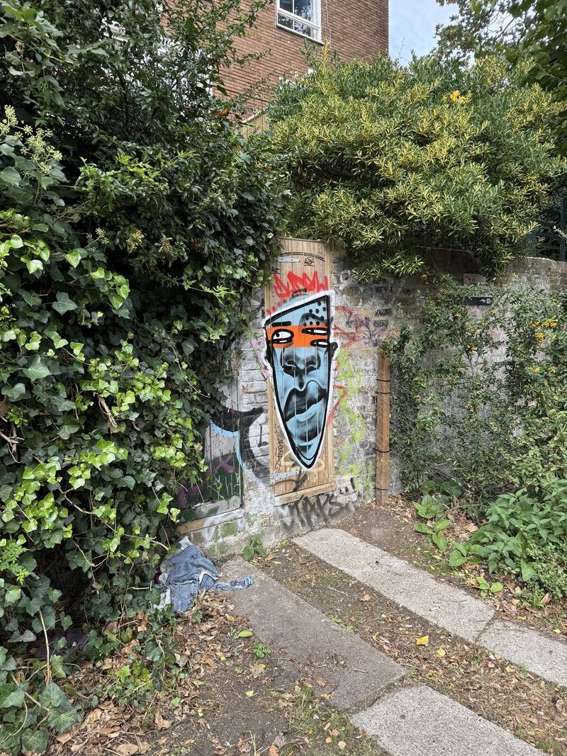 Un appariscente volto a graffiti su una porta, lungo il percorso verso Camden.