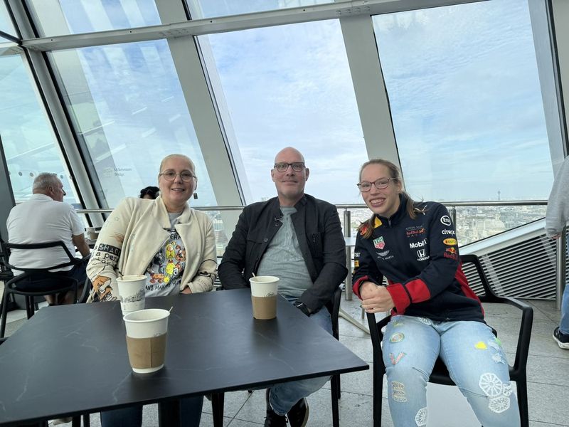 Liek, Marc e B'Elana al tavolo con il caffè, con tutta Londra sullo sfondo.