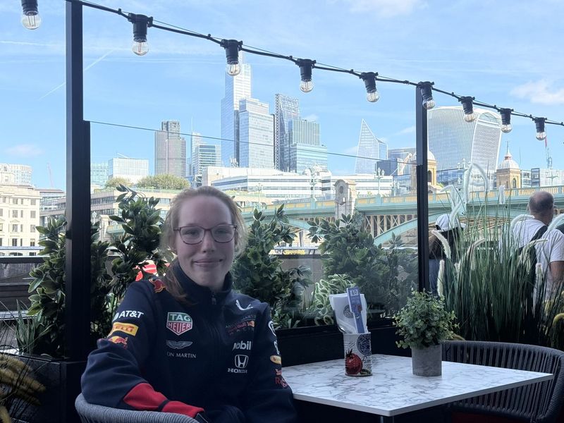 B'Elana al tavolo in terrazza, con la stessa vista ancora una volta, ad altezza tavolo.