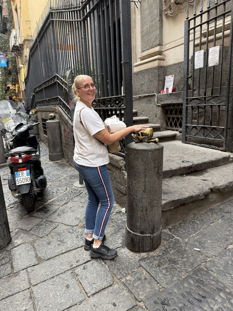 At the Purgatorio ad Arco, Liek touches one of the bronze skulls for luck.